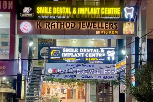 Smile Dental & Implant Centre clinic signboard featuring Dr. P. Sudhakar and Dr. K. Nounika dental implant and cosmetic dentistry services